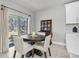 Cozy dining area with a round wooden table, four chairs, and natural light from sliding glass doors at 8352 Greenway Ave, Wesley Chapel, FL 33544