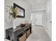 Inviting hallway with tile flooring, a decorative console table, and neutral wall colors at 8352 Greenway Ave, Wesley Chapel, FL 33544