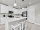 Contemporary kitchen featuring white cabinetry, stainless steel appliances, and a center island with seating at 8352 Greenway Ave, Wesley Chapel, FL 33544