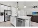 Open-concept kitchen with white cabinets, stainless steel appliances, and a large island with bar stools at 8352 Greenway Ave, Wesley Chapel, FL 33544