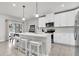 Bright kitchen with white cabinets, a center island with bar seating, and stainless steel appliances at 8352 Greenway Ave, Wesley Chapel, FL 33544