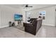Open living room features tile floors, neutral paint, ceiling fan and large windows with plenty of natural light at 8352 Greenway Ave, Wesley Chapel, FL 33544