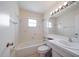 Bright bathroom featuring a shower-tub combo, a toilet, vanity with sink, and a large mirror at 8445 Calais N, Pinellas Park, FL 33781