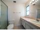 Bathroom features a shower, toilet, vanity with sink, and large mirror with natural lighting at 8445 Calais N, Pinellas Park, FL 33781