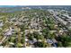 An aerial view showing homes, trees, a lake and some commercial buildings in the distance at 910 Lakeside Dr, Largo, FL 33778