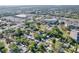 An aerial view of a neighborhood showing homes, trees, a shopping center and some commercial buildings at 910 Lakeside Dr, Largo, FL 33778