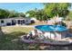 Backyard featuring an above-ground pool, tiki hut, and privacy fence, ideal for outdoor enjoyment and relaxation at 910 Lakeside Dr, Largo, FL 33778