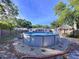 A backyard featuring an above-ground pool, tiki hut, and landscaping at 910 Lakeside Dr, Largo, FL 33778