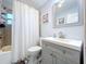 Bright bathroom featuring a shower/tub, gray vanity, and tile accents, creating a modern and clean space at 910 Lakeside Dr, Largo, FL 33778