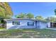 A well-maintained single-story home with gray brick accents, shuttered windows, and attached garage at 910 Lakeside Dr, Largo, FL 33778