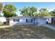 A single-story home features a well-manicured lawn and attached garage, complemented by dark shutters at 910 Lakeside Dr, Largo, FL 33778