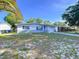 A cozy single-story home with dark shutters and an attached garage, set in a tranquil neighborhood at 910 Lakeside Dr, Largo, FL 33778