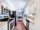 Open concept kitchen featuring stainless appliances and wood flooring that leads to a dining area at 910 Lakeside Dr, Largo, FL 33778