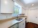 Bright kitchen features white cabinets, stainless steel appliances, and window at 910 Lakeside Dr, Largo, FL 33778