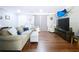 Spacious living area with plush seating, hardwood floors, and a mounted television for entertainment at 910 Lakeside Dr, Largo, FL 33778