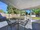 Covered patio with outdoor furniture, providing a comfortable space for relaxing and enjoying the backyard view at 910 Lakeside Dr, Largo, FL 33778