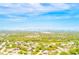 Neighborhood aerial view showing mature trees, homes, and distant water view with a blue sky at 921 Woodland Dr, Palm Harbor, FL 34683