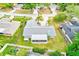 Aerial view of a home with a screened-in lanai, fenced yard, mature trees and landscaping at 921 Woodland Dr, Palm Harbor, FL 34683