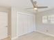 This bedroom offers a ceiling fan, tile flooring, and a large closet with white doors at 921 Woodland Dr, Palm Harbor, FL 34683