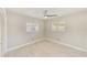 Bright bedroom with modern ceiling fan, neutral paint, plantation shutters and tile floors at 921 Woodland Dr, Palm Harbor, FL 34683