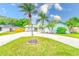 Charming single Gathering home featuring lush landscaping and a well-manicured lawn at 921 Woodland Dr, Palm Harbor, FL 34683