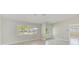 Bright living room featuring large windows, tile floors, and a stylish modern light fixture at 921 Woodland Dr, Palm Harbor, FL 34683