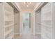 Walk-in closet features built-in shelving and easy access to the modern bathroom at 921 Woodland Dr, Palm Harbor, FL 34683