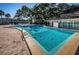 Large, inviting community pool surrounded by lush landscaping, with lounge chairs and shaded areas for residents to enjoy at 938 Virginia St # 308, Dunedin, FL 34698