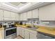 Well-lit kitchen featuring stainless steel appliances, light wood counters, and ample cabinet space at 12760 Indian Rocks Rd # 571, Largo, FL 33774
