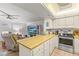 Bright kitchen with wooden counters, white cabinets, and stainless steel appliances adjacent to living room at 12760 Indian Rocks Rd # 571, Largo, FL 33774