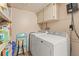 Functional laundry area with washer, dryer, storage shelves, and overhead cabinets at 12760 Indian Rocks Rd # 571, Largo, FL 33774