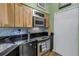 Well-equipped kitchen featuring wooden cabinetry, stainless steel appliances, and a mosaic backsplash at 100 4Th S Ave # 207, St Petersburg, FL 33701