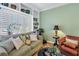 Comfortable living room with green sofa, built-in shelving, shuttered windows, and a brown leather chair at 100 4Th S Ave # 207, St Petersburg, FL 33701