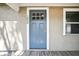 Close-up of the front door featuring a light blue door with a white frame and the house number 1000 at 1000 8Th Sw Ave, Largo, FL 33770
