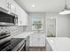 Modern kitchen featuring stainless appliances, white cabinets, and attractive backsplash at 1000 8Th Sw Ave, Largo, FL 33770