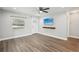 Bright living room with a ceiling fan, wood-look floors, mounted TV, and plenty of natural light at 1000 8Th Sw Ave, Largo, FL 33770