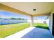Covered patio overlooking the fenced backyard with lush green grass at 1001 Culbreath Green Ct, Ruskin, FL 33570
