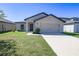 Charming single-story home with a well-maintained lawn, a two-car garage and neutral color palette at 1001 Culbreath Green Ct, Ruskin, FL 33570