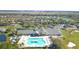 Aerial view of the community's clubhouse, pool, and golf course with homes and a large greenbelt in the background at 10048 Cleghorn Dr, San Antonio, FL 33576