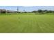 Lush green golf course with flag in hole and blue sky in the distance on a sunny day at 10048 Cleghorn Dr, San Antonio, FL 33576