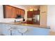 Well-equipped kitchen with wood cabinets, granite countertops, and a stainless steel refrigerator, creating a functional space at 10048 Cleghorn Dr, San Antonio, FL 33576