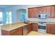 A well-appointed kitchen with a stainless steel dishwasher and oven, complemented by stylish wood cabinets at 10048 Cleghorn Dr, San Antonio, FL 33576