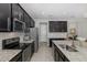 Modern kitchen features stainless steel appliances, granite countertops and sleek dark cabinets at 1010 Mango Ct, Oldsmar, FL 34677