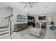 Open concept living room with large windows, sectional sofa, tv and staircase at 1010 Mango Ct, Oldsmar, FL 34677