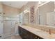 Luxurious bathroom featuring double sinks, dark cabinets, a large walk-in shower, and stylish mirrors at 10612 Glencorse Ter, Bradenton, FL 34211