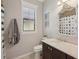 Stylish bathroom with decorative framed mirror, dark wood cabinet, and neutral wall color at 10612 Glencorse Ter, Bradenton, FL 34211