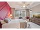 Well-lit bedroom featuring magenta accent wall, neutral carpet, and large windows with natural light at 10612 Glencorse Ter, Bradenton, FL 34211