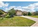 Charming single-story home featuring lush green lawns, a brick-paved driveway and a well-manicured tropical landscape at 10612 Glencorse Ter, Bradenton, FL 34211