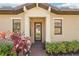 Inviting front entrance with a glass-paneled door, red pavers, and lush landscaping at 10612 Glencorse Ter, Bradenton, FL 34211