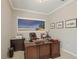 Spacious home office with a large wooden desk, beach mural, and tasteful decor at 10612 Glencorse Ter, Bradenton, FL 34211